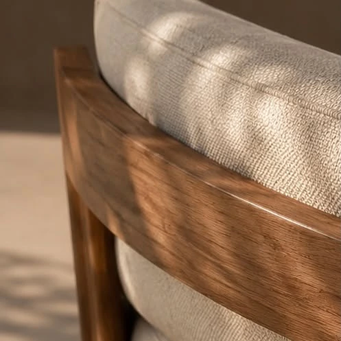Detail of a warm wooden sofa frame and textured neutral upholstery