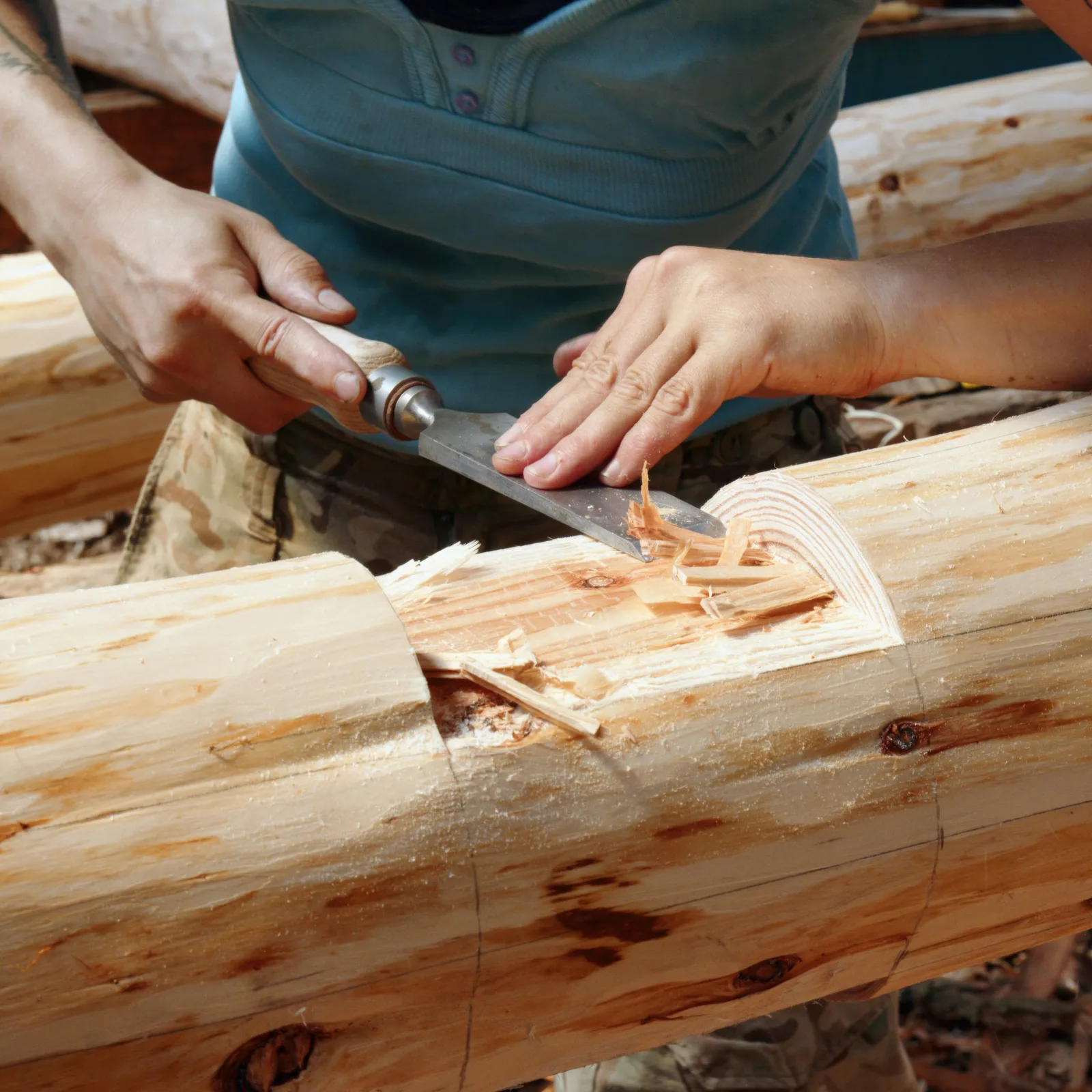 Close-up of a hand plane shaping timber amid curled wood shavings